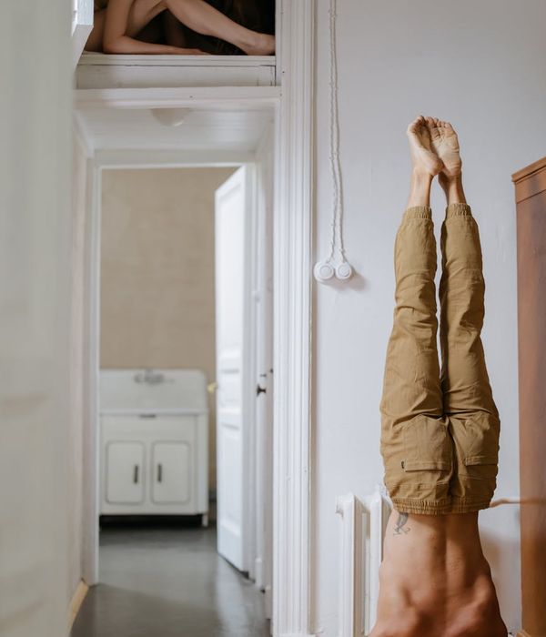 Man performing a controlled core strength exercise in a bright room.